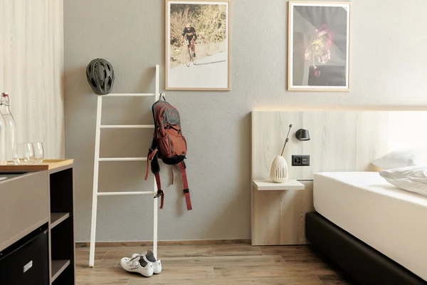 Natur- und Bikehotel Balga: Wo Radeln auf Genuss trifft © Paolo Vaccariello Hotelzimmer mit Fahrradzubehör neben einem Bett und dekorativen Bildern