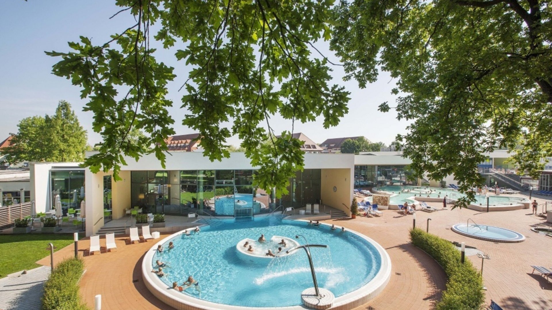 Outdoor pools and wellness area of a modern spa on a sunny day