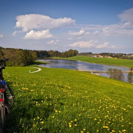 Fiets langs een pad op een groene heuvel met uitzicht op een meer