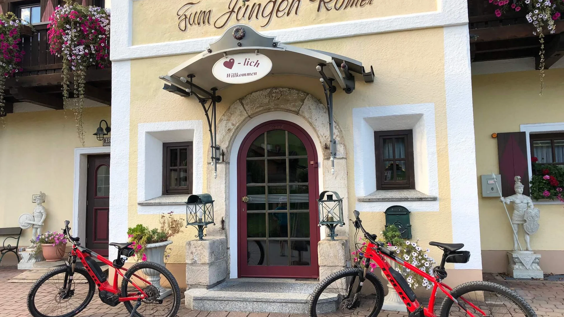 Bicycles parked in front of a building entrance labeled Zum jungen Römer
