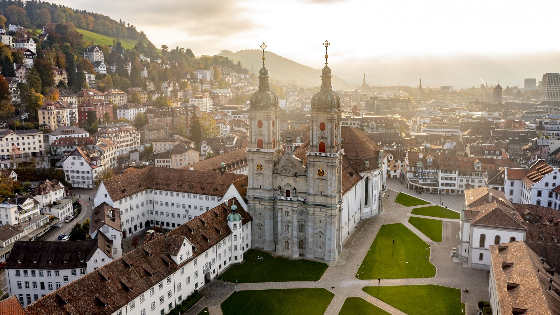 Aerial view of St. Gallen church with city and hills in the background