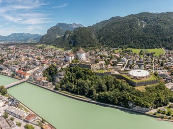 Panoramic view of Kufstein town with fortress and Inn river by forested mountains