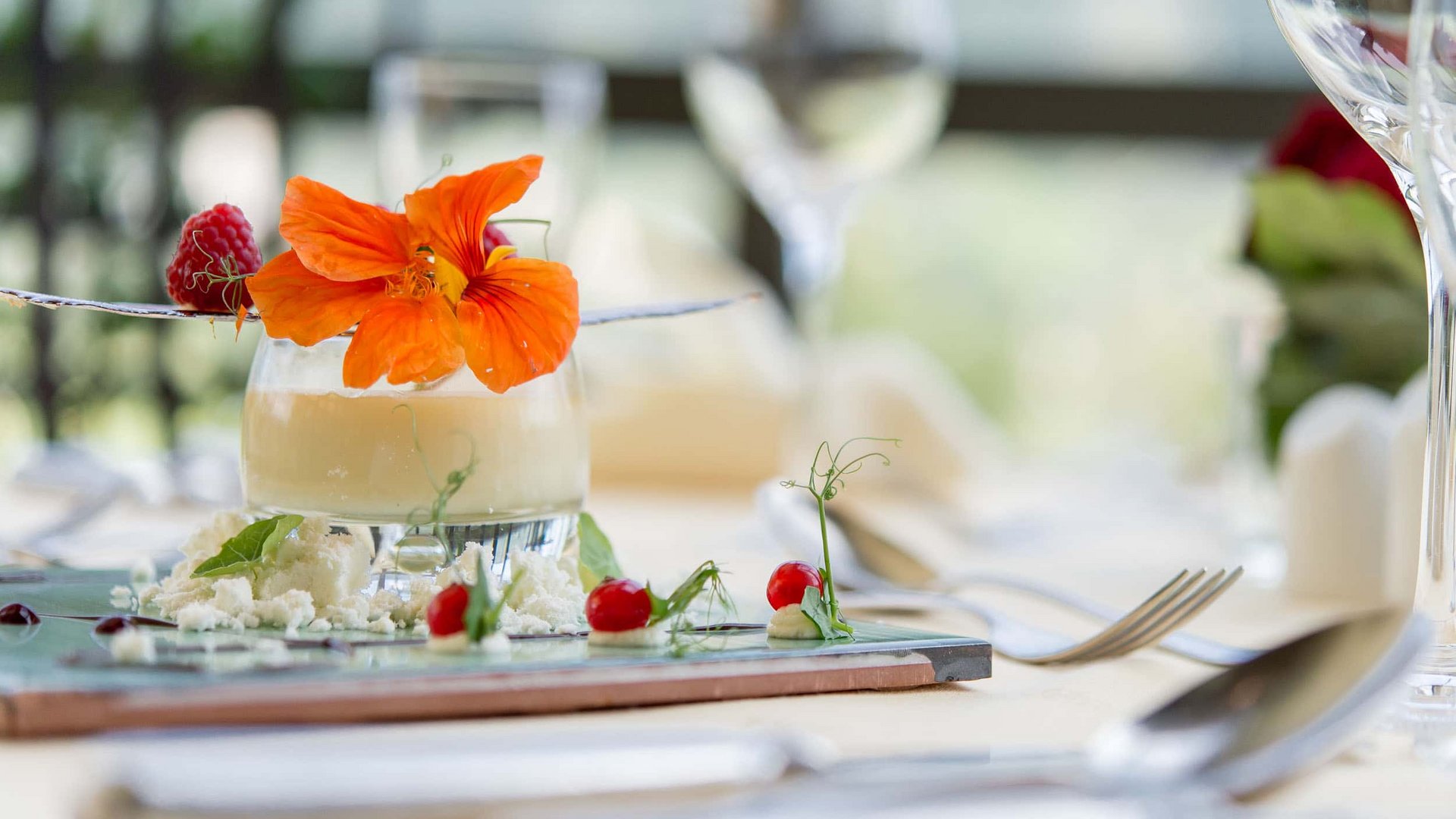 Elegant dessert with edible flower and berries on set dining table