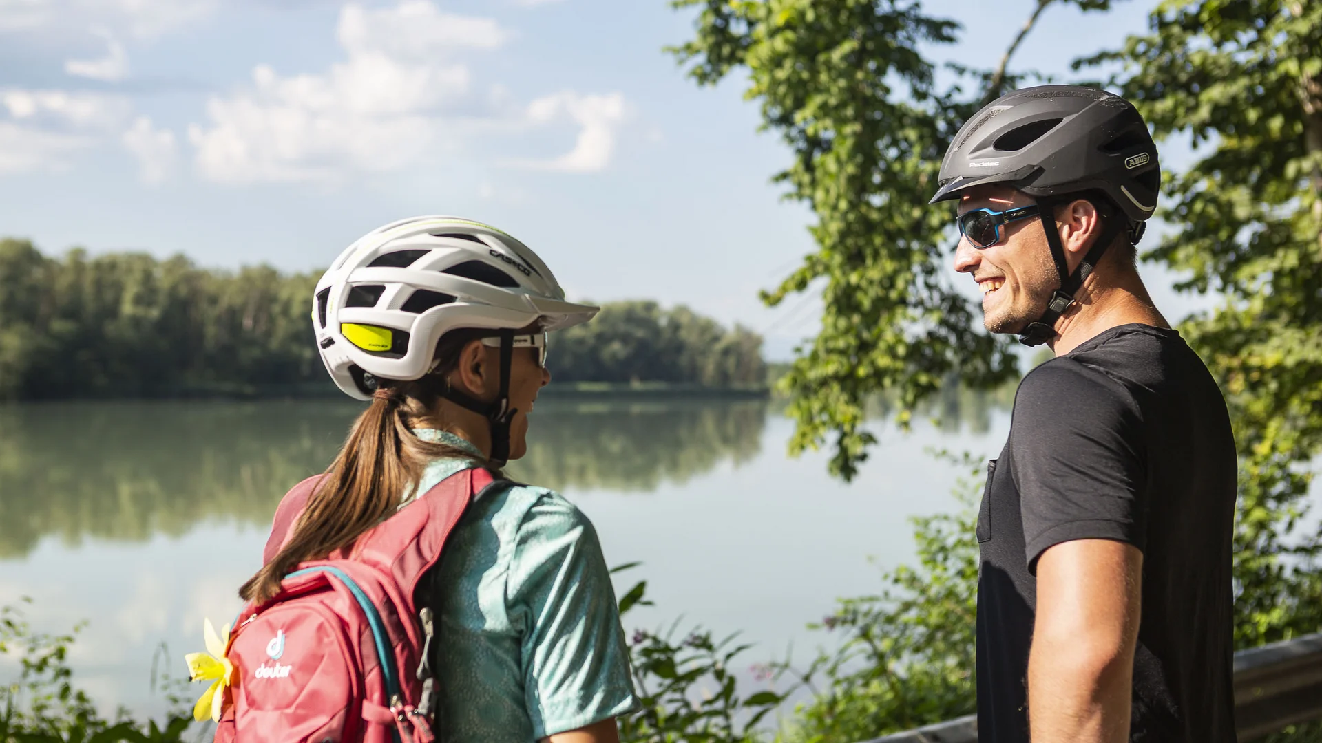 Zwei Radfahrer stehen am Seeufer und unterhalten sich