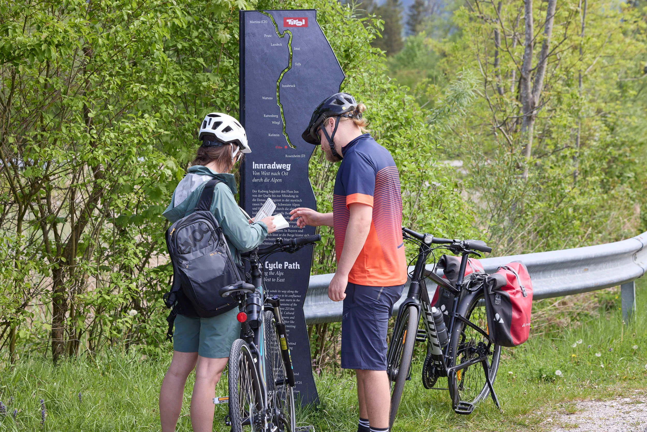 Packliste für einen perfekten Radurlaub © TVB Kufsteinerland - Simon Hausberger Zwei Radfahrer lesen eine Infotafel am Innradweg in Tirol