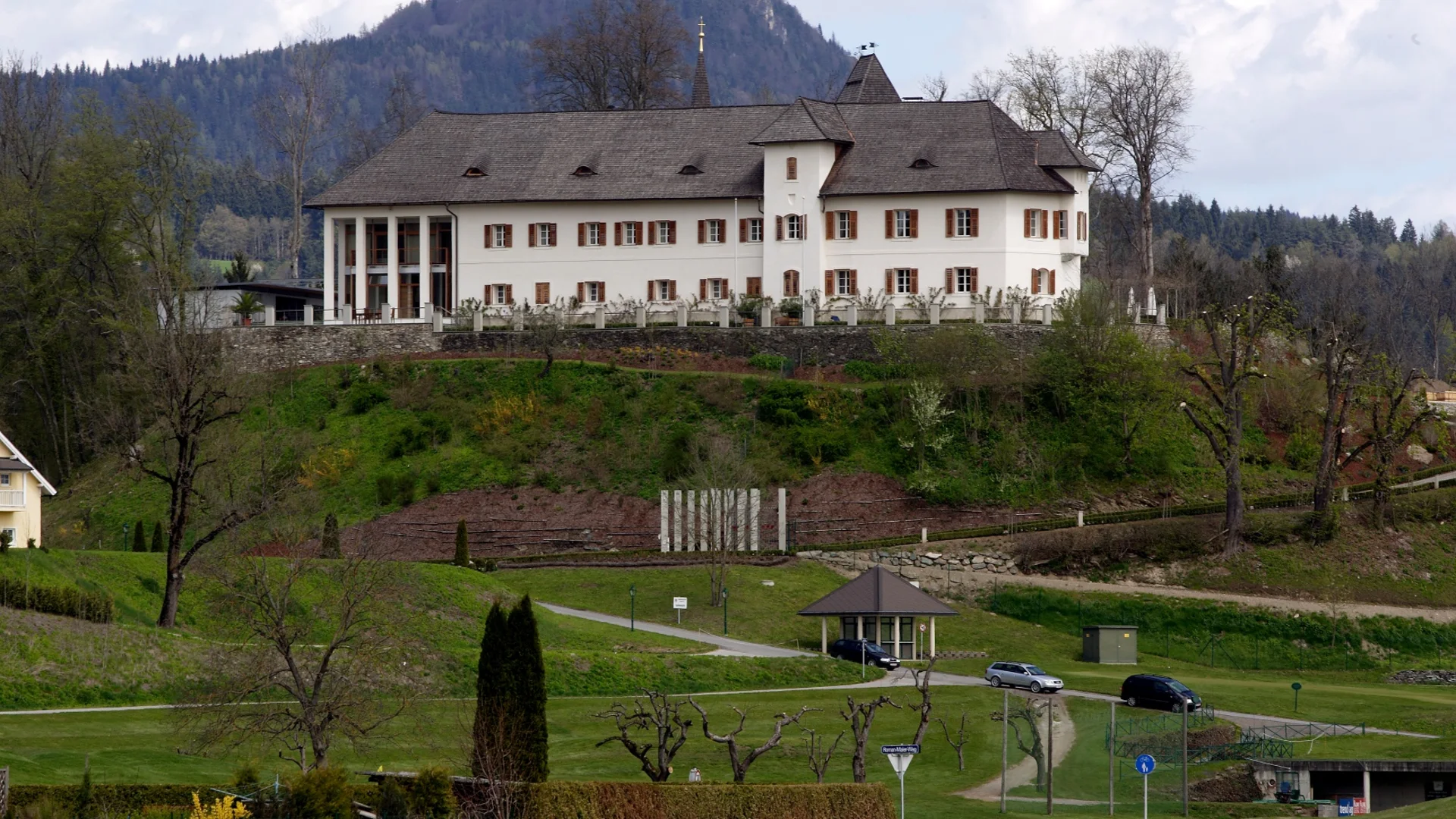 Historisch kasteel op een heuvel met bergen op de achtergrond