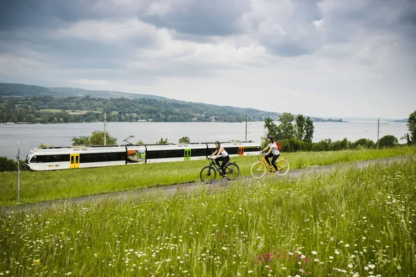 Radeln im Thurgau © Ivo Scholz Zwei Radfahrer fahren auf einem Weg neben einer Bahnstrecke am See
