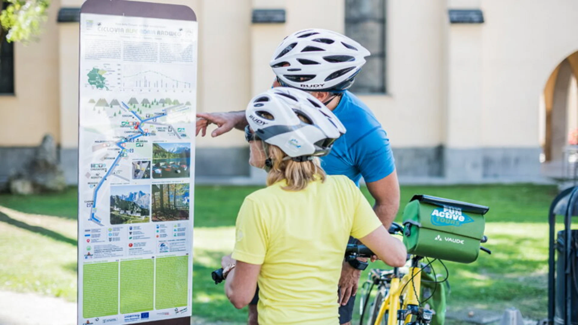 Dolomites - Trieste © FunActive Tours Two cyclists with helmets reading a map on an information board