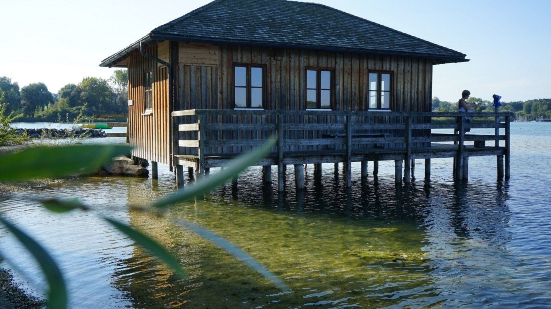 Wooden house on stilts over clear lake water