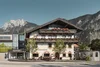 Collective enquiries Traditional alpine house with flower decorations against mountains and clear sky