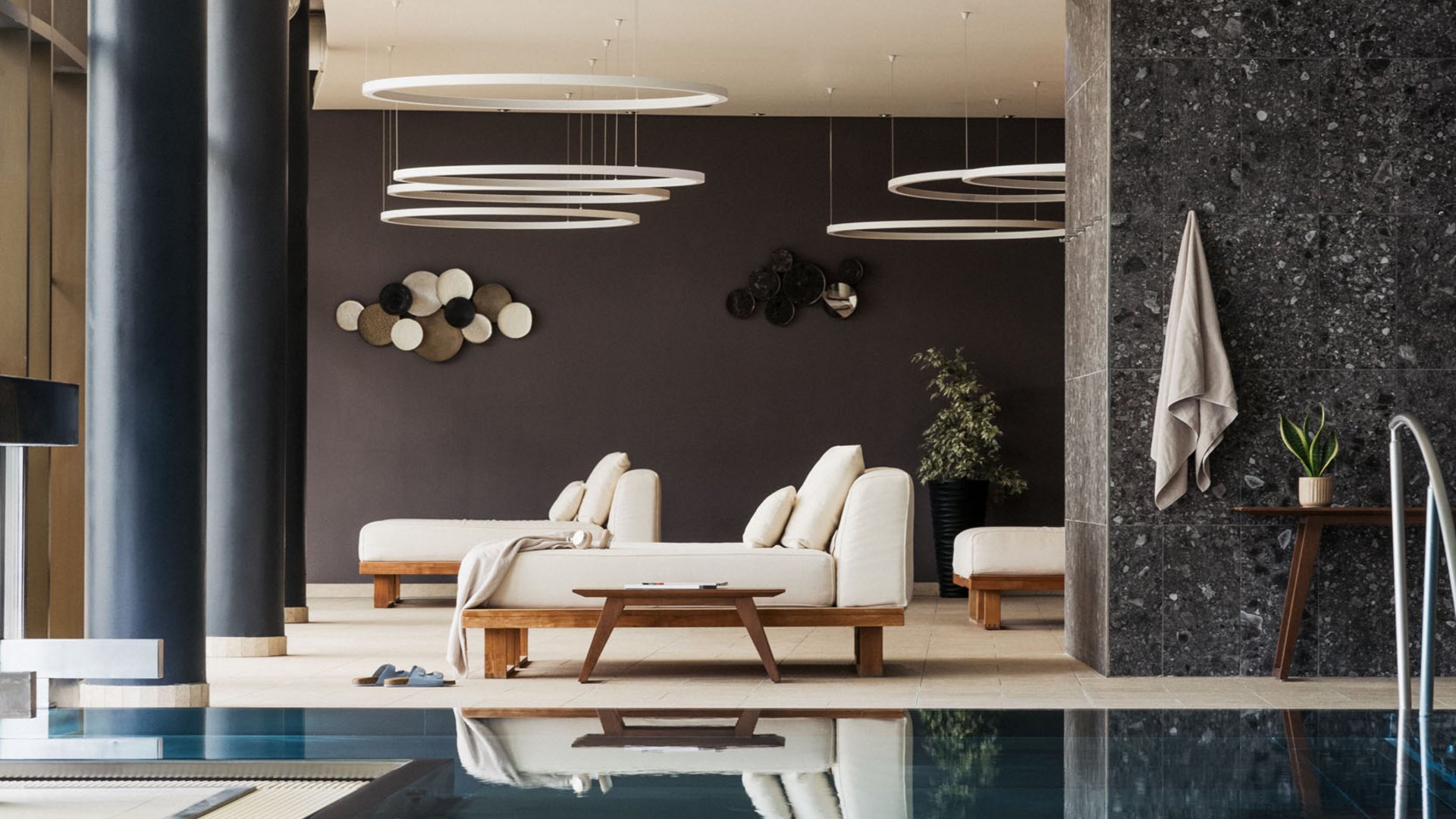 Modern indoor pool with lounge chairs and decorative wall art