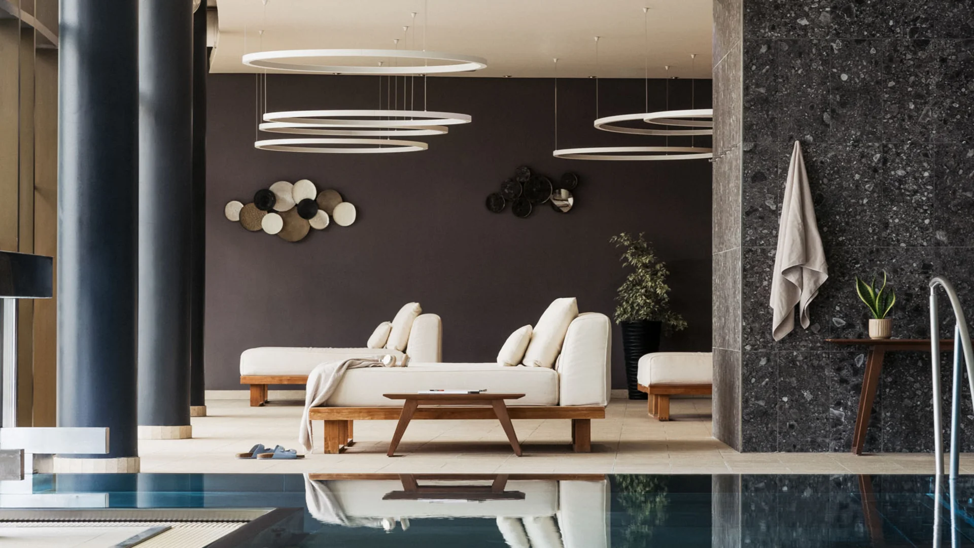 Modern indoor pool with lounge chairs and decorative wall art