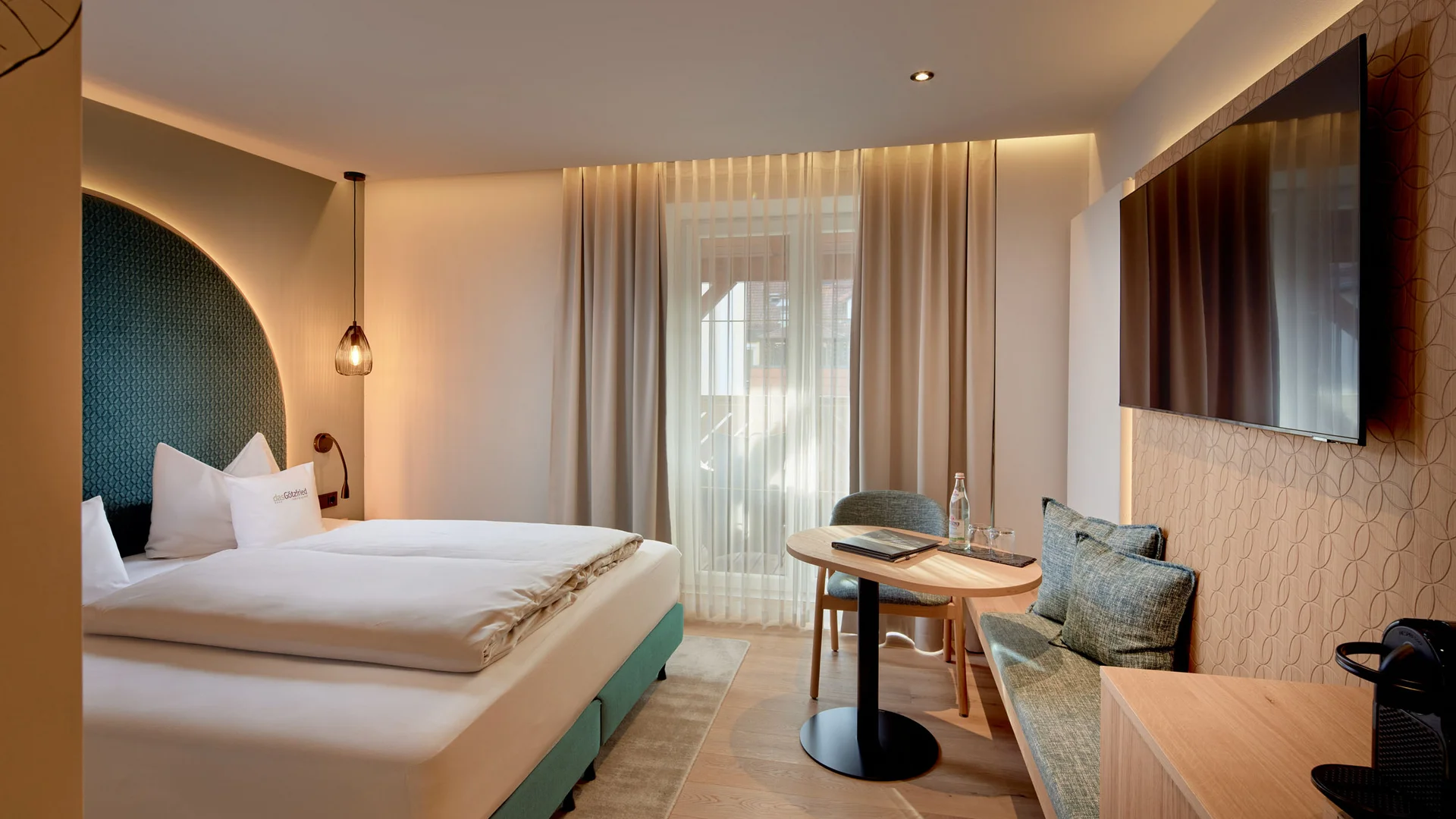 Garden & Spa Hotel das Götzfried **** © Michael Huber Fotographie Modern hotelkamer met tweepersoonsbed, zithoek en grote tv