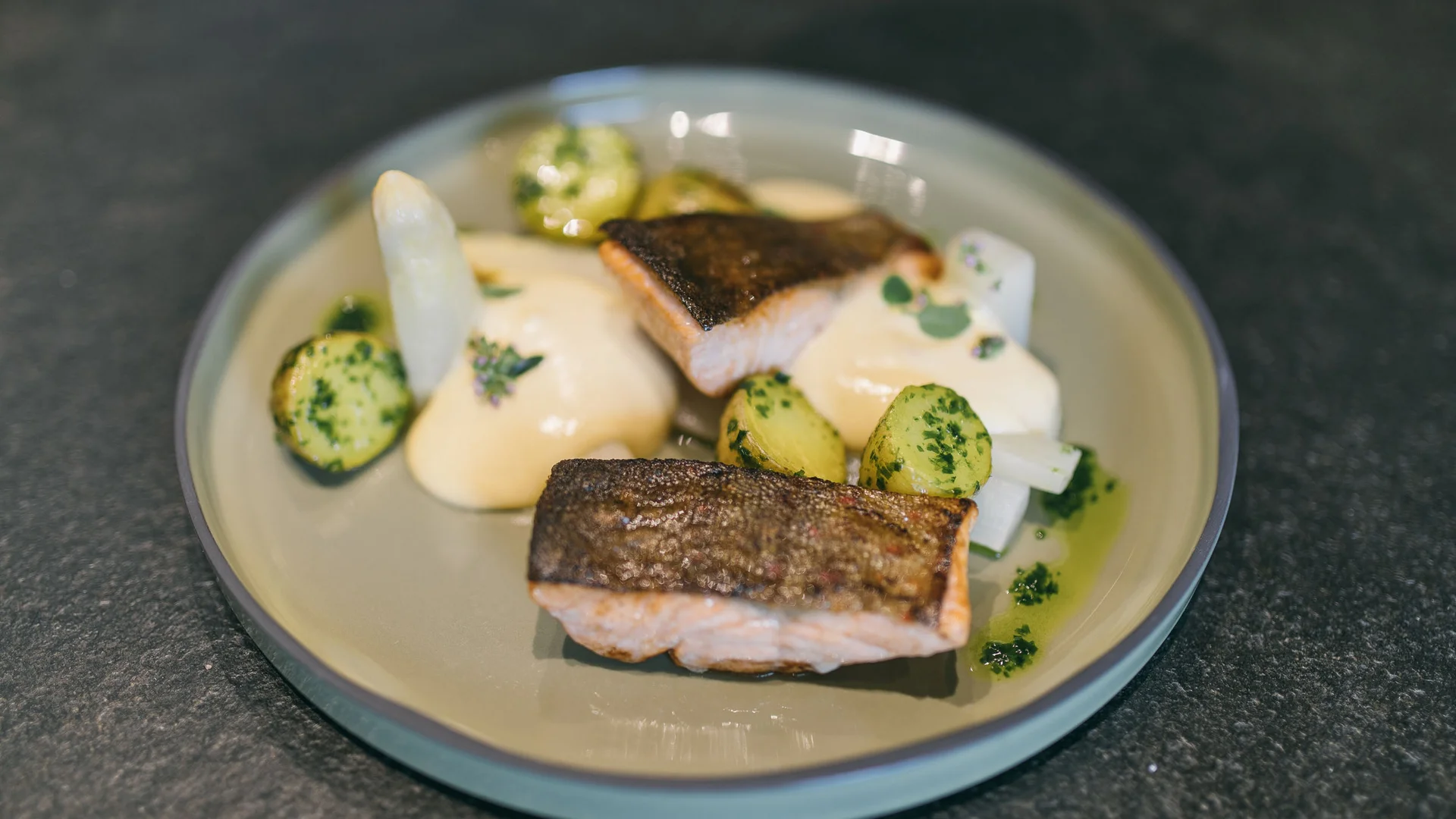 Grilled salmon fillets with potatoes and sauce on a plate