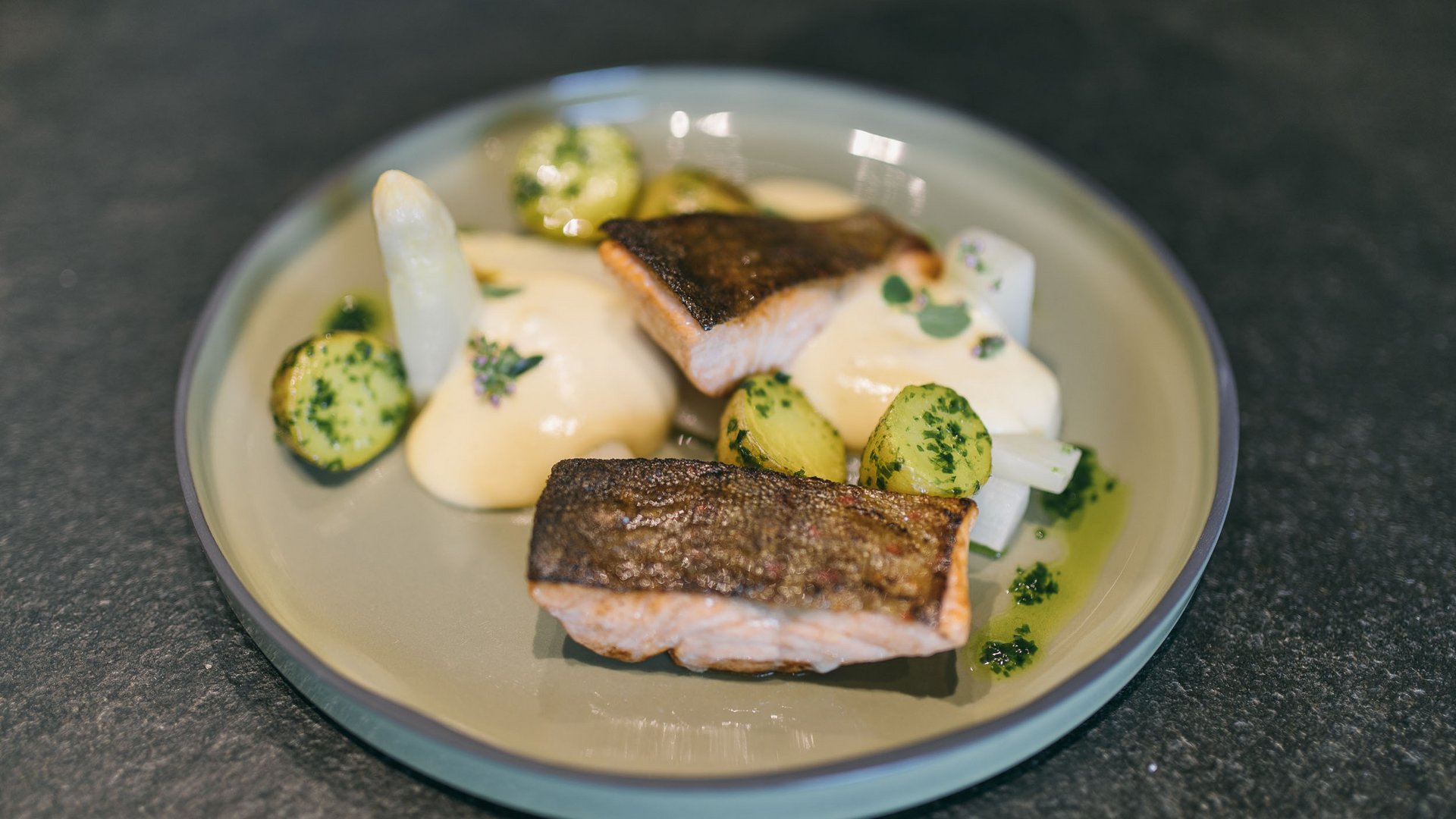 Grilled salmon fillets with potatoes and sauce on a plate