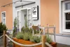 Collective enquiries Entrance of JUFA Hotel with outdoor table and plants