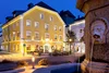 Collective enquiries Illuminated yellow building next to a fountain at night in a town