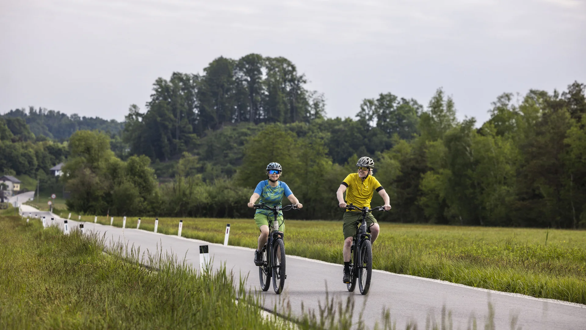 Radfahren ohne Höhenmeter-Stress im Quellenviertel © Velontour - Heiko Mandl Zwei Radfahrer fahren auf einer Landstraße durch eine grüne Landschaft