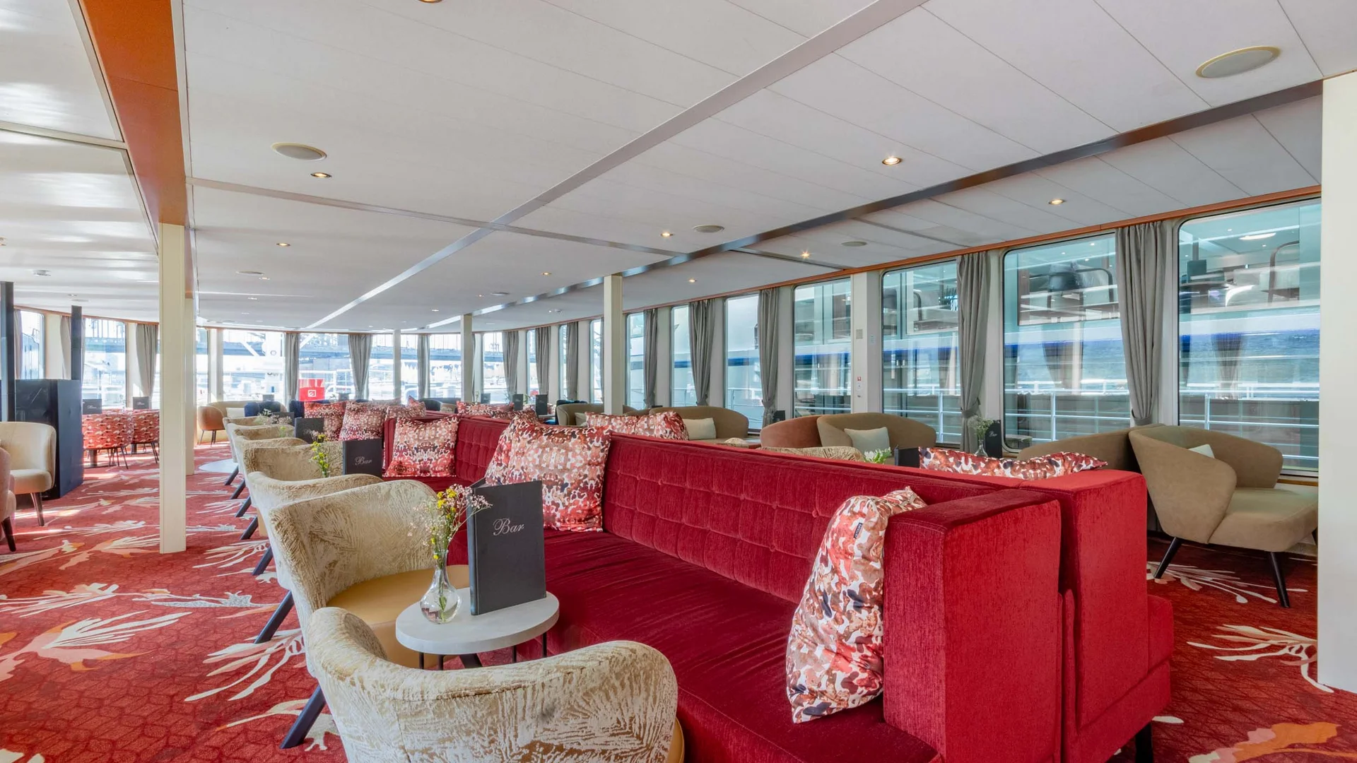 Cycle tour between Passau and Vienna © Rad+Reisen - Tobias Bayer Interior of a lounge with red sofas and small tables on a floral patterned carpet