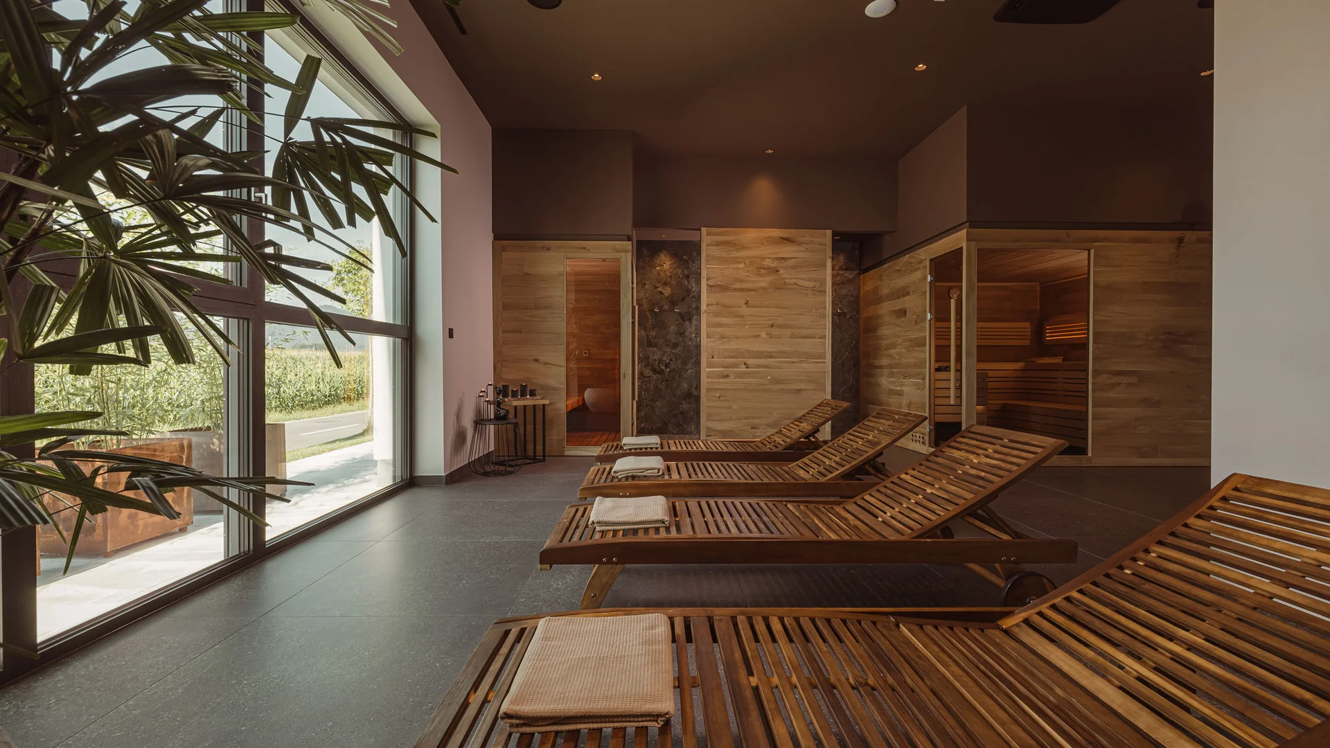 Rustruimte met houten ligstoelen en sauna in modern wellnesscentrum