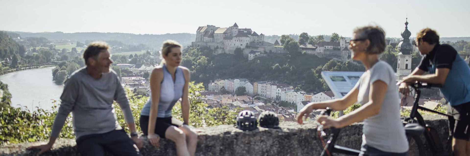 Four cyclists enjoying view of castle and river in the background