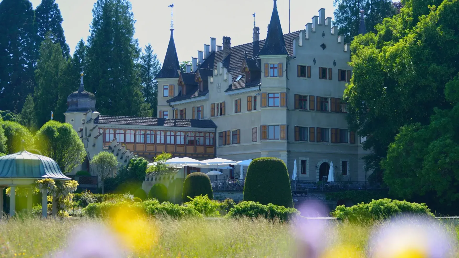 Kasteel met torens en tuinweide met kleurrijke bloemen