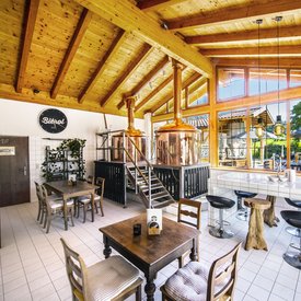 Cozy brewery interior with wooden ceiling and copper fermenters