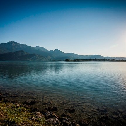 Sunrise over a calm lake with mountains in the background