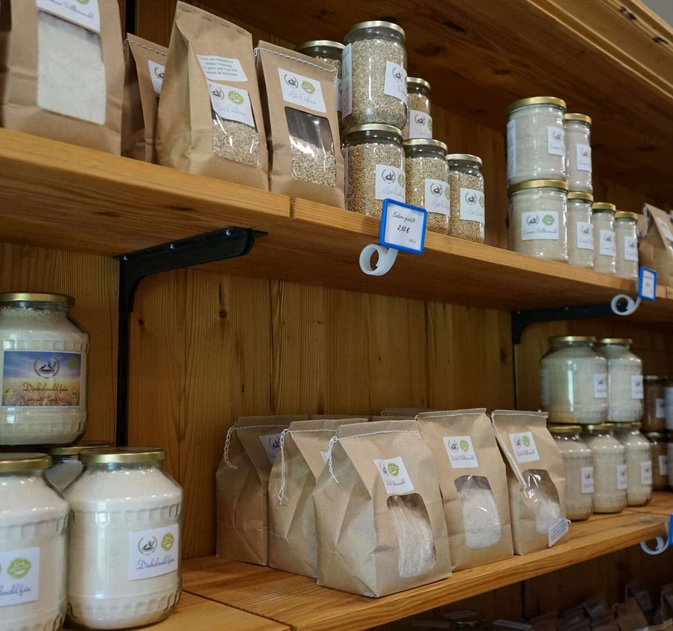 Shelf with glass jars and paper bags of grains and flour