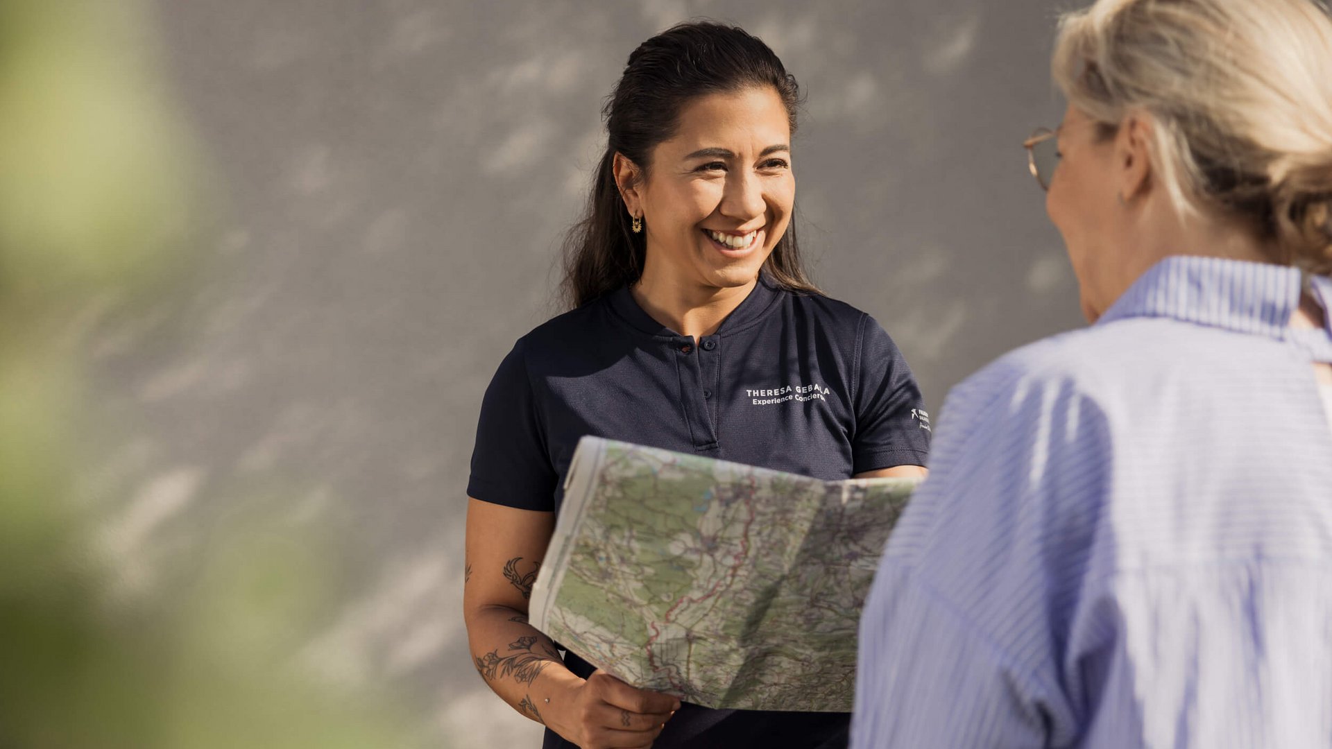 Woman showing a map to another woman and smiling warmly