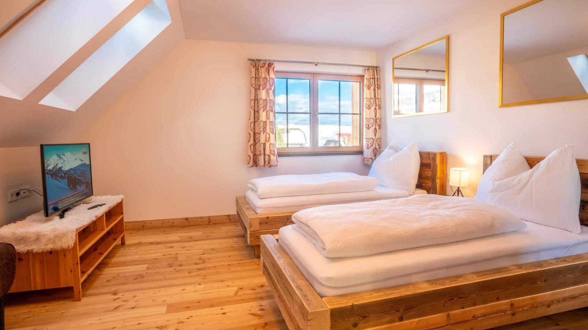 Cozy bedroom with two wooden beds and a television