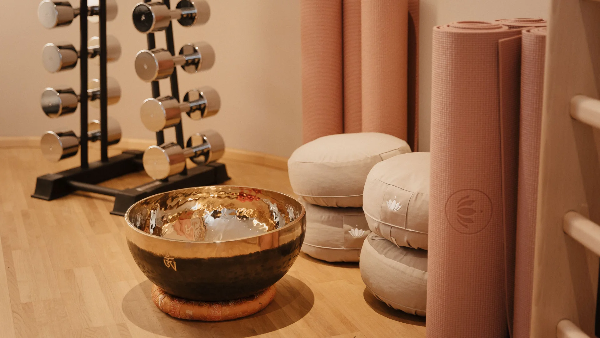 Yoga mats, meditation cushions, and a singing bowl in a calm room