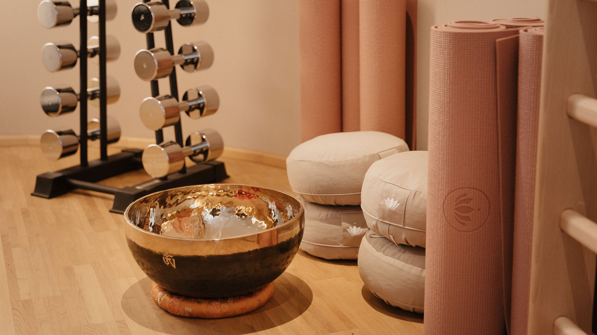Yoga mats, meditation cushions, and a singing bowl in a calm room