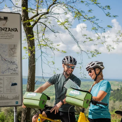 Twee fietsers bekijken een kaart bij de Parenzana-route met landschap