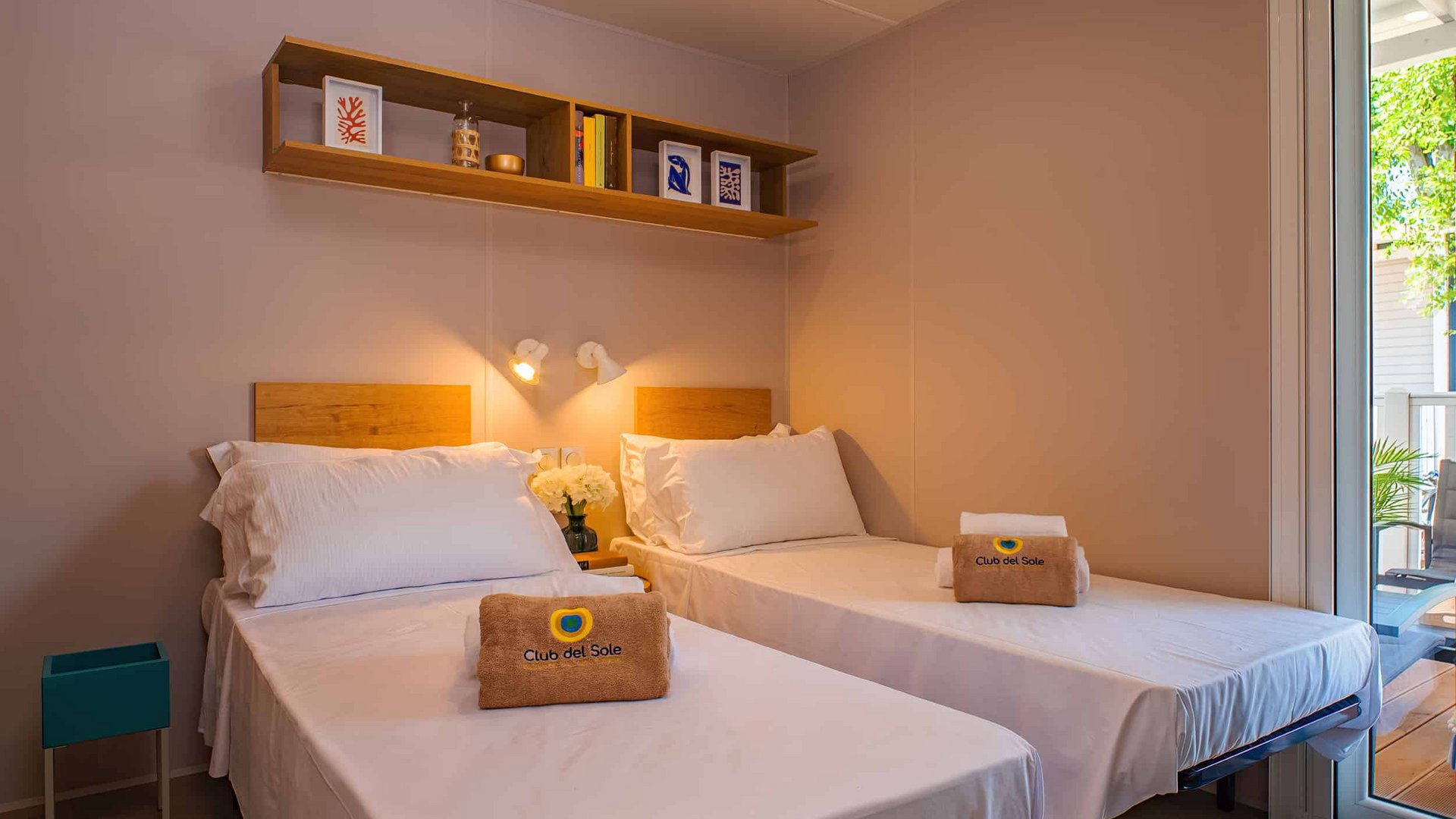 Twin bedroom with white bedding and balcony visible through glass door