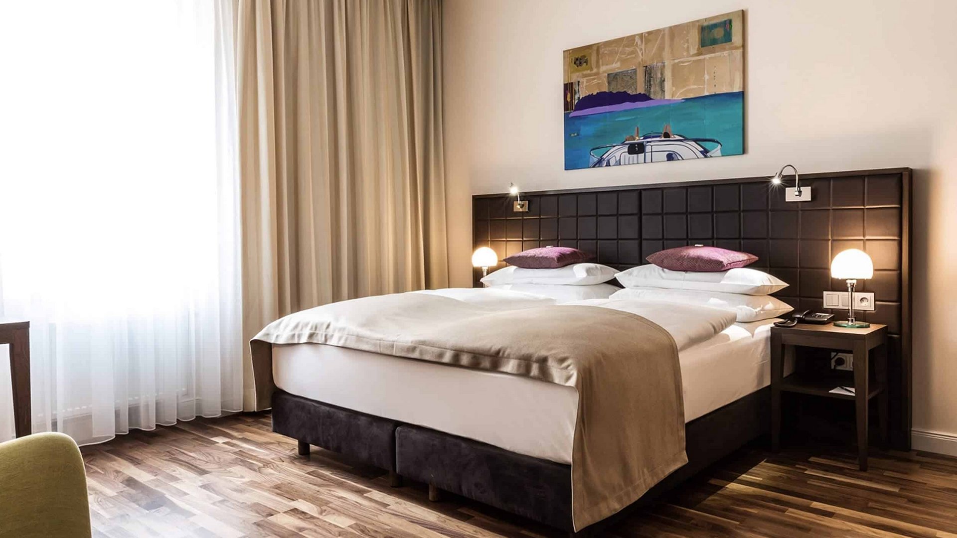 Modern hotel room with double bed and wall art