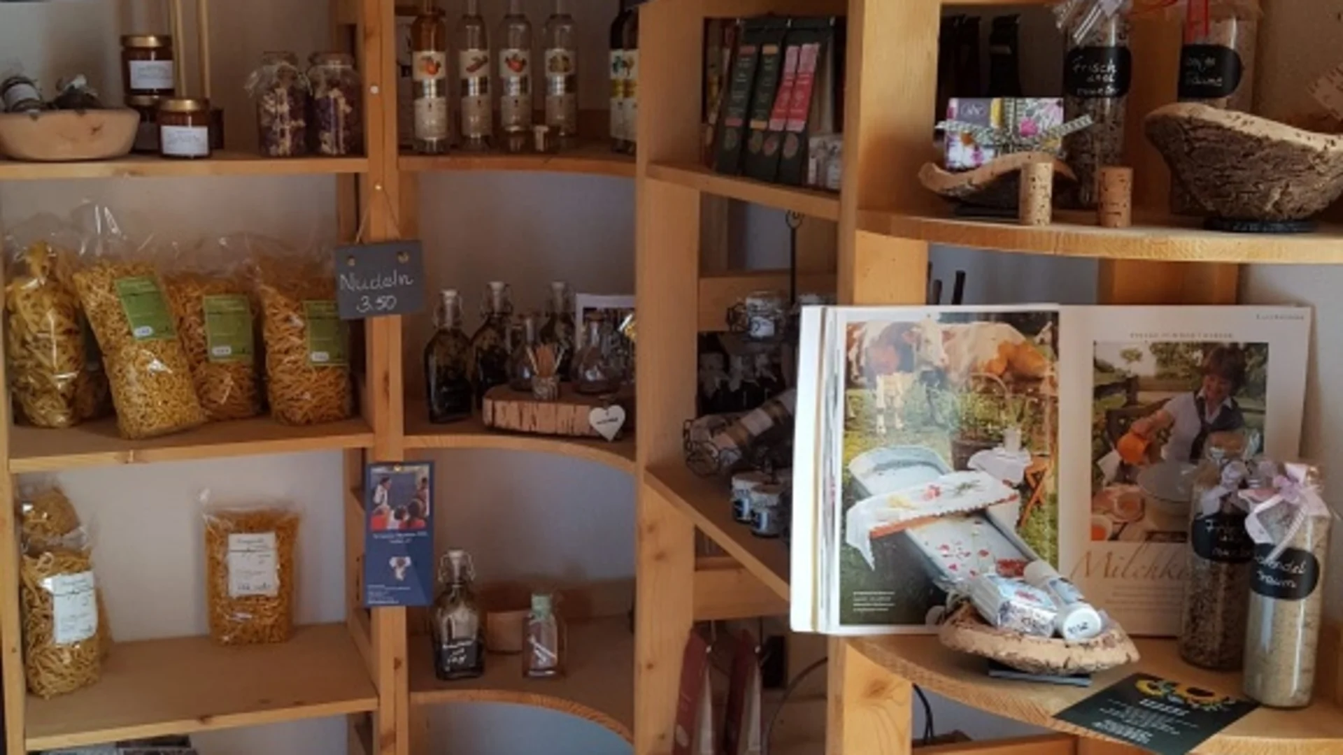 Holzregale mit Lebensmitteln und Büchern in einem kleinen Laden