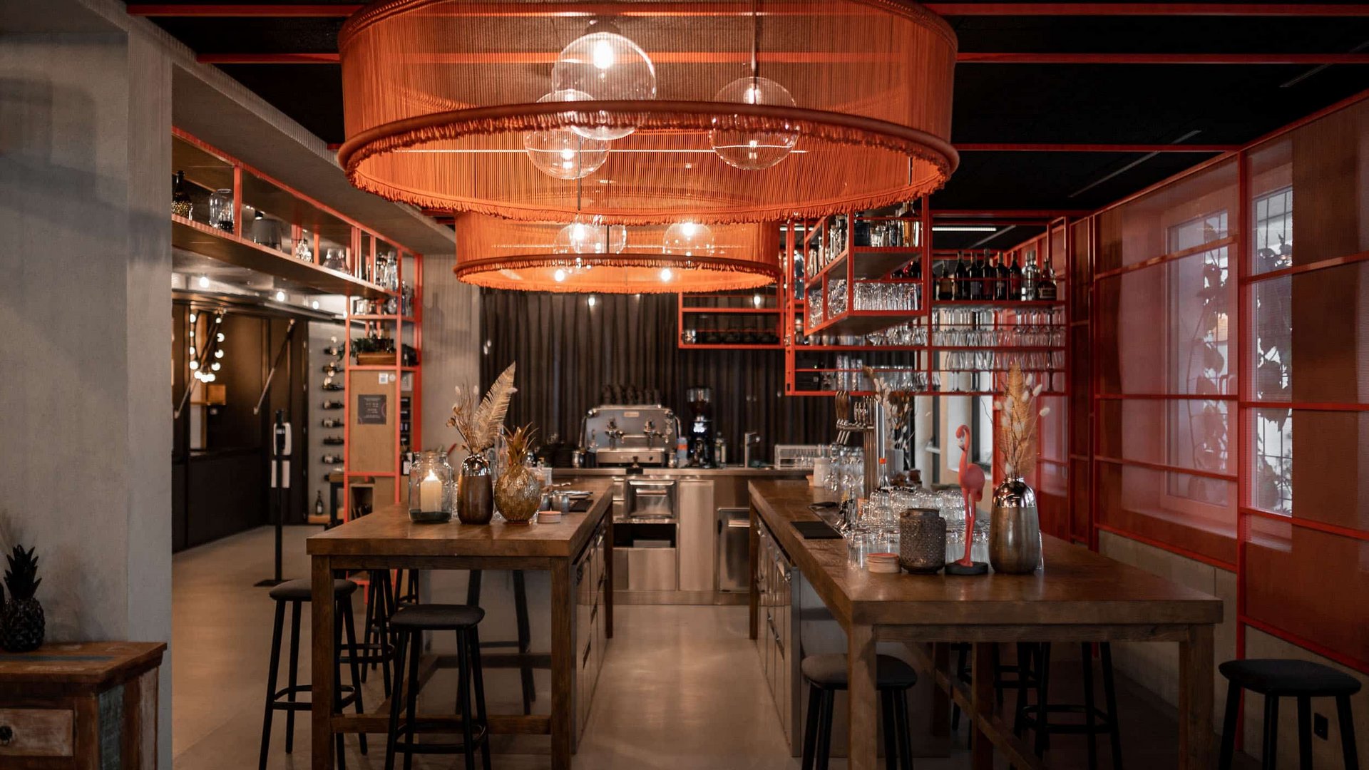 Modern bar with wooden counters, orange lampshades, and stools