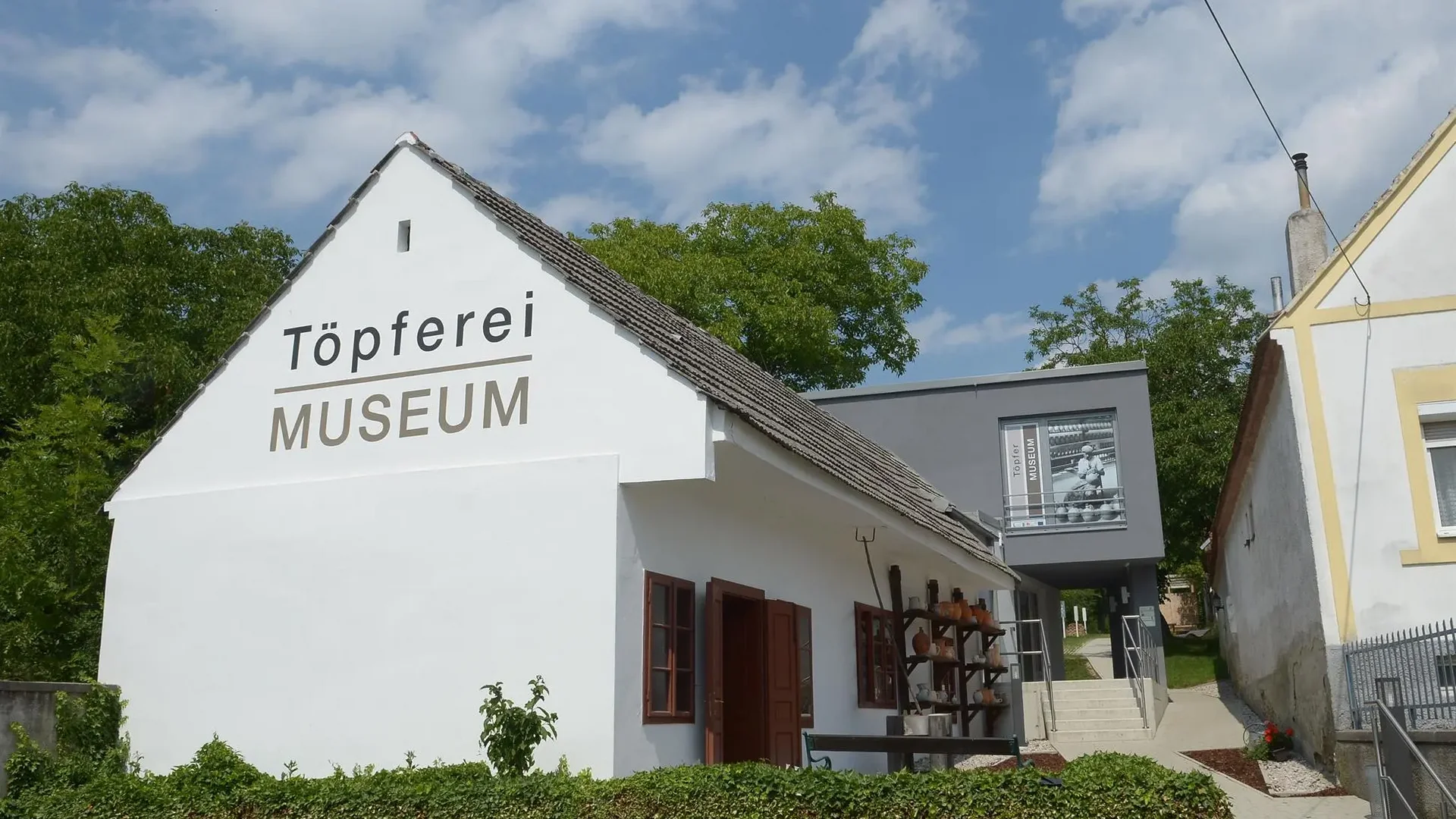 Tour-Detail Weißes Gebäude mit der Aufschrift Töpferei Museum unter blauem Himmel
