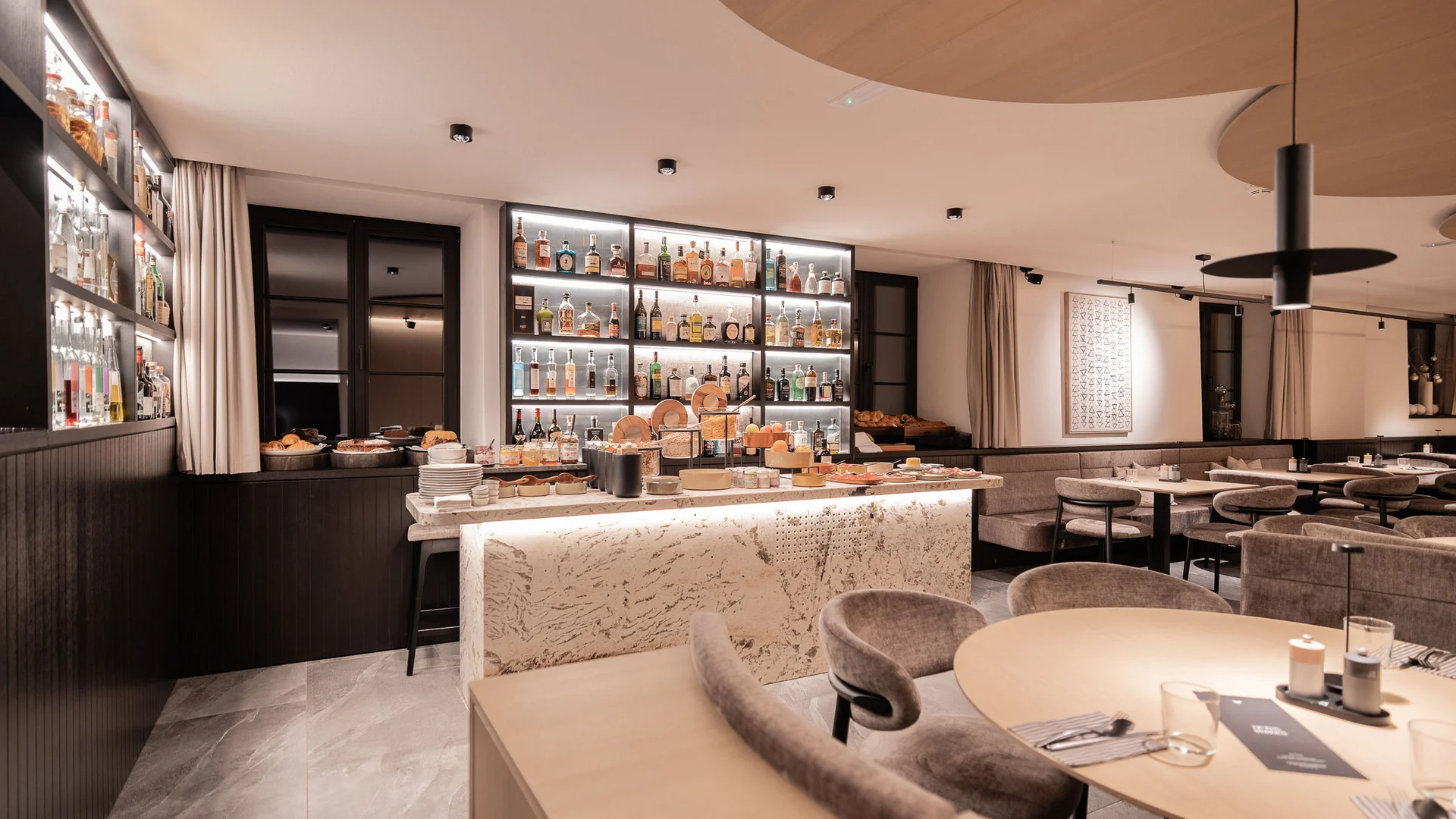 Moderne bar met verlichte planken en gezellige zithoeken