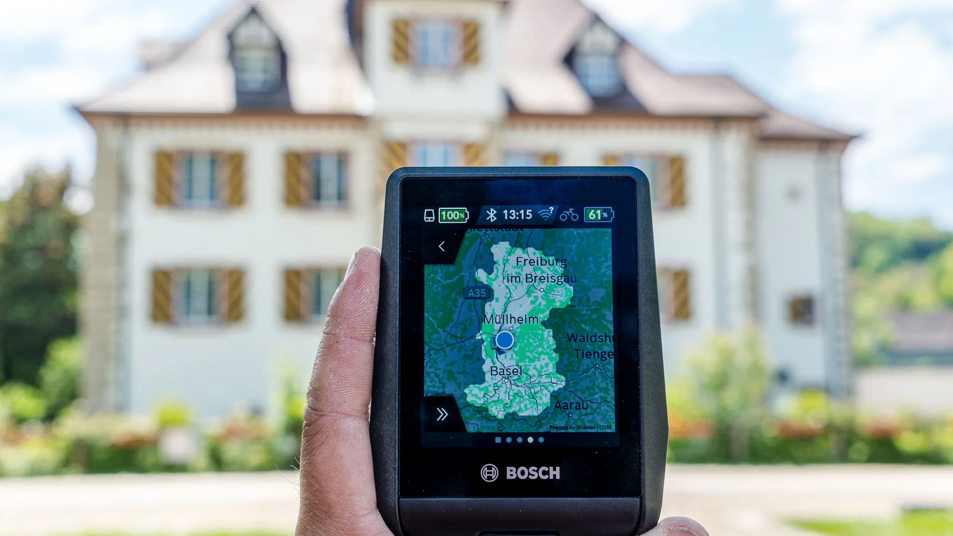 Hand houdt Bosch navigatieapparaat met kaart van regio Basel