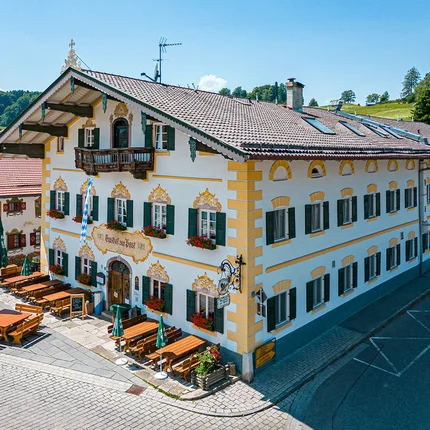 Traditionelles bayerisches Gasthaus mit Außensitzplätzen und Blumendekoration