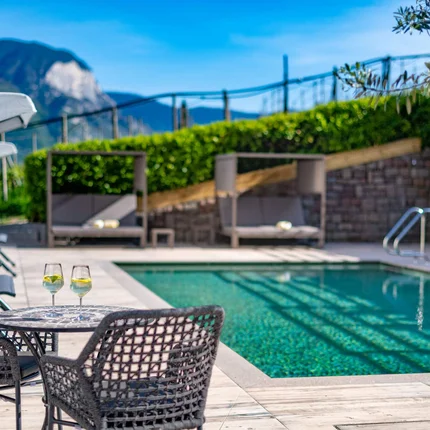 Pool mit Sitzbereich und zwei Gläsern auf dem Tisch bei sonnigem Wetter