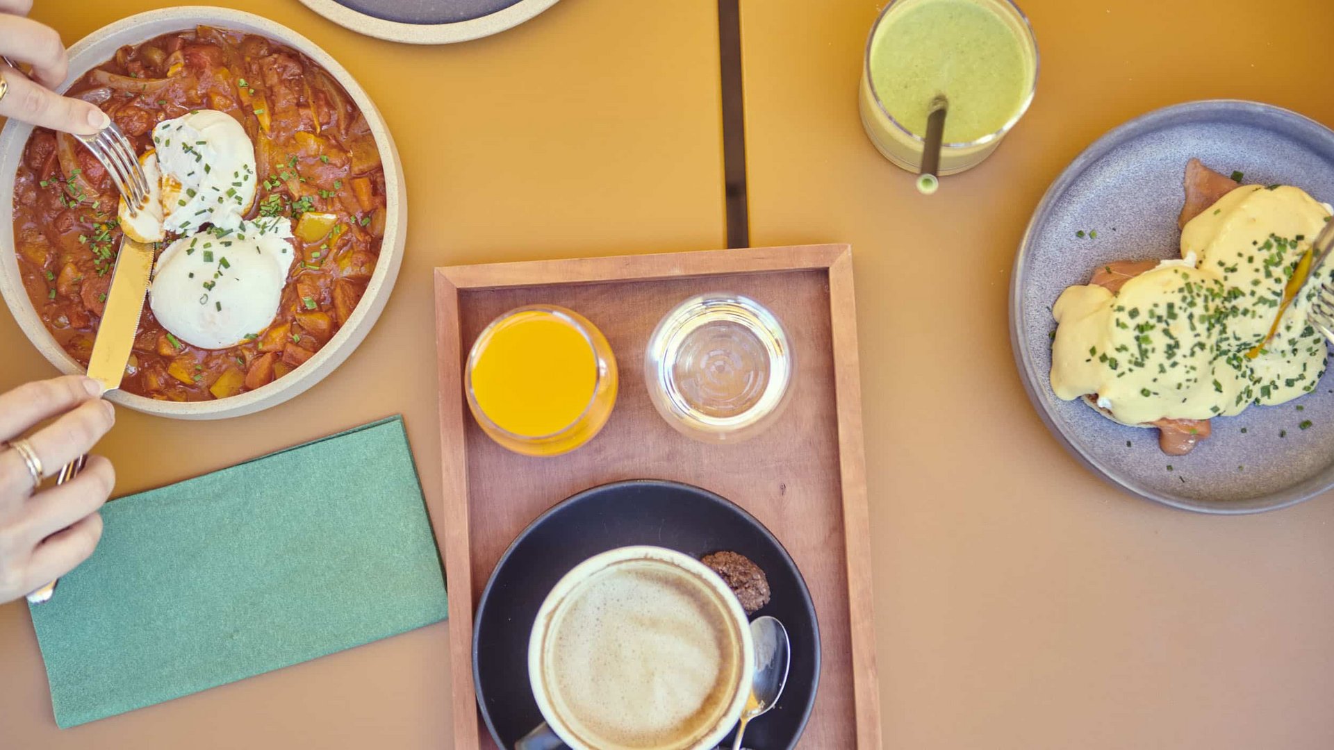 Breakfast with eggs, juice, coffee and green smoothie on a table