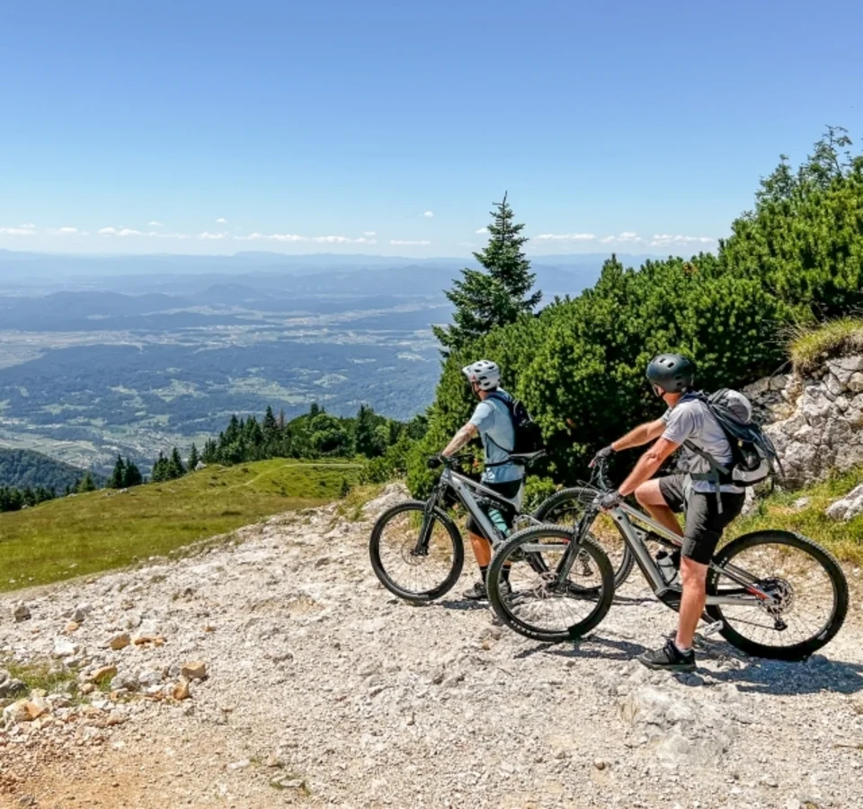 Zwei Radfahrer mit Helmen auf Bergweg mit Panoramablick