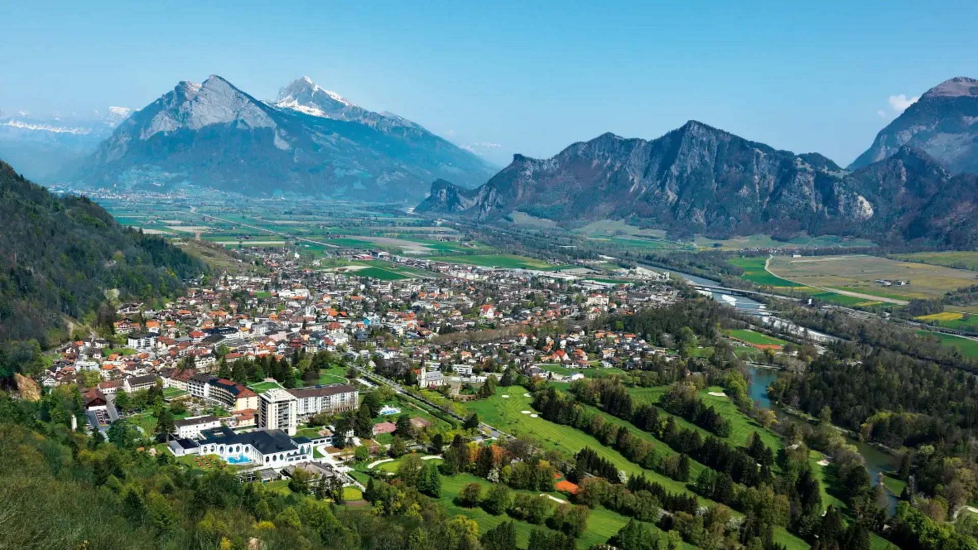 Uitzicht op een stad in een vallei met bergen en rivierlandschap