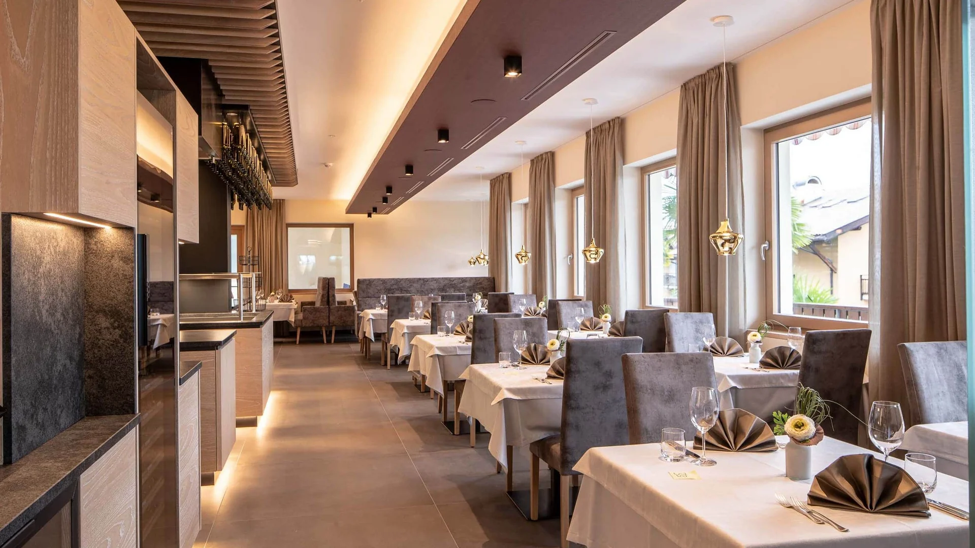 Elegantes Restaurant mit gedeckten Tischen und Stühlen an großen Fenstern