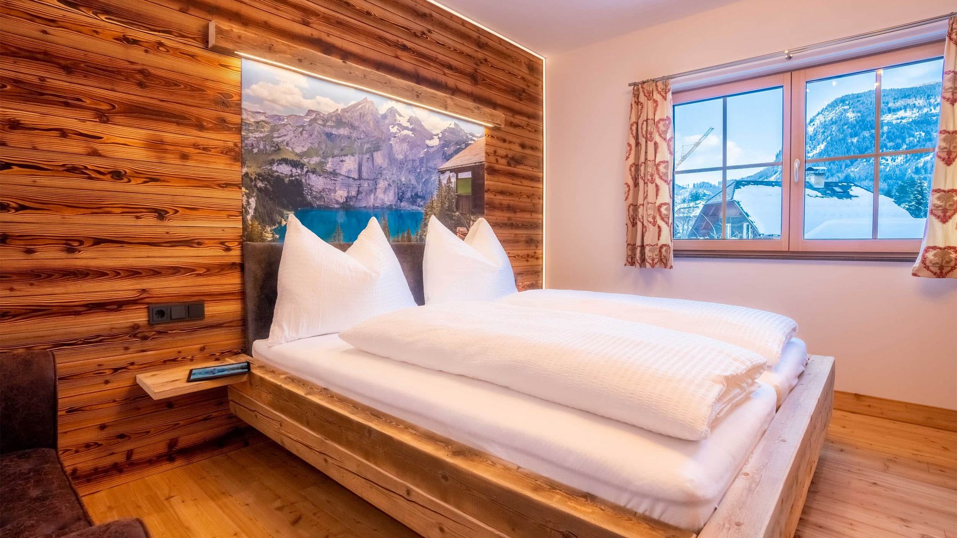 Cozy bedroom with wooden furniture and mountain view through the window