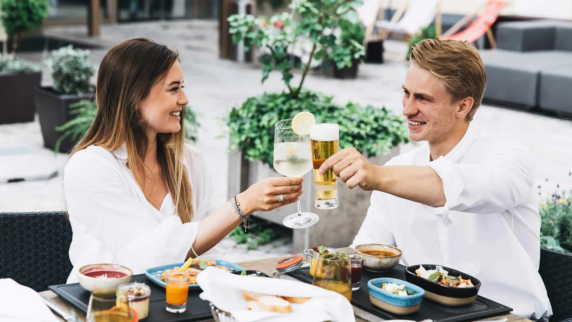 Koppel die met drankjes toost tijdens een lunch buiten