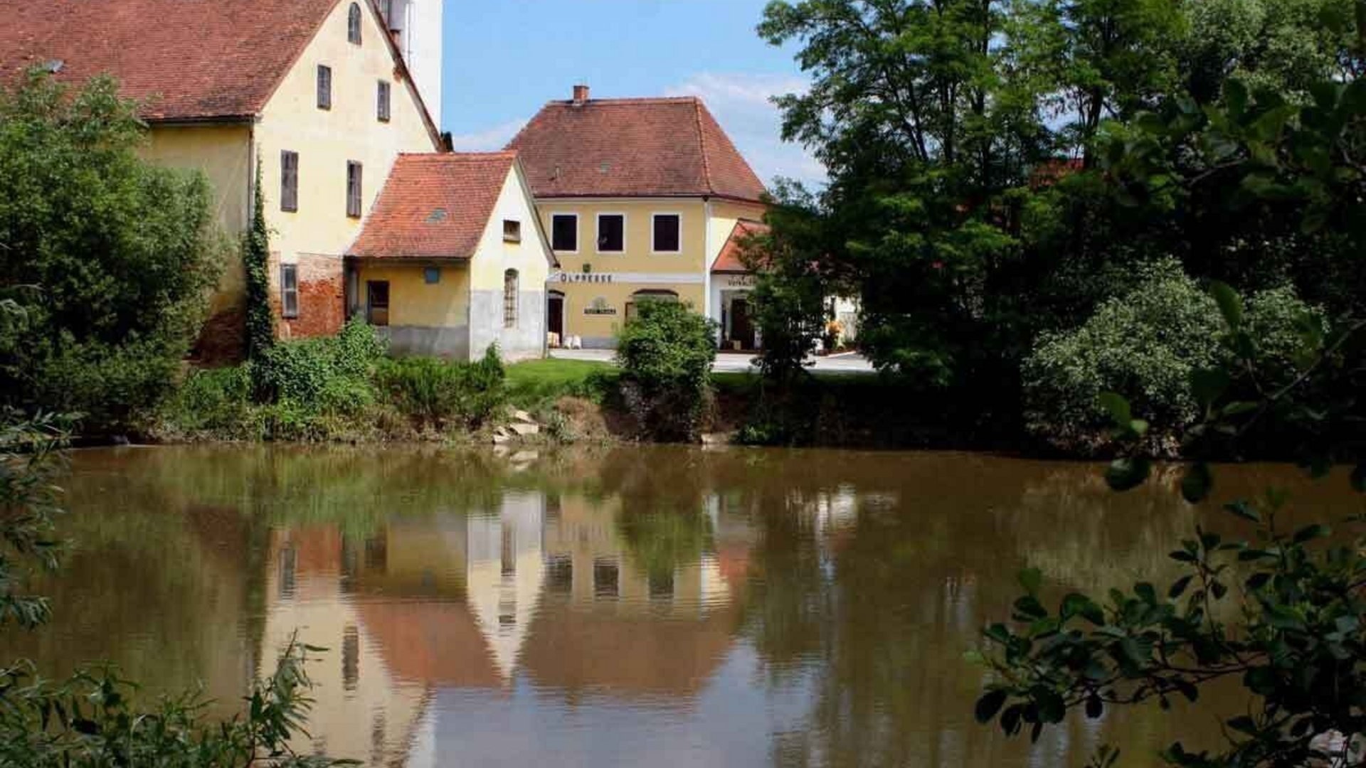 Old houses by a riverbank with reflection in the water